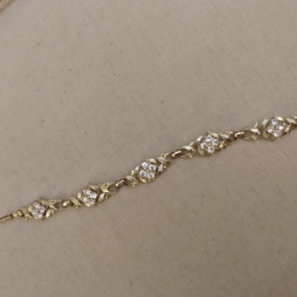 Silver tone metal link bracelet with clear stone clusters.